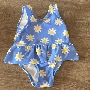 Little girls blue one piece with white and yellow flowers.